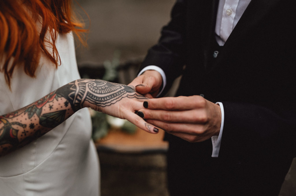 El novio le pone el anillo a la novia en una boda muy rock-era