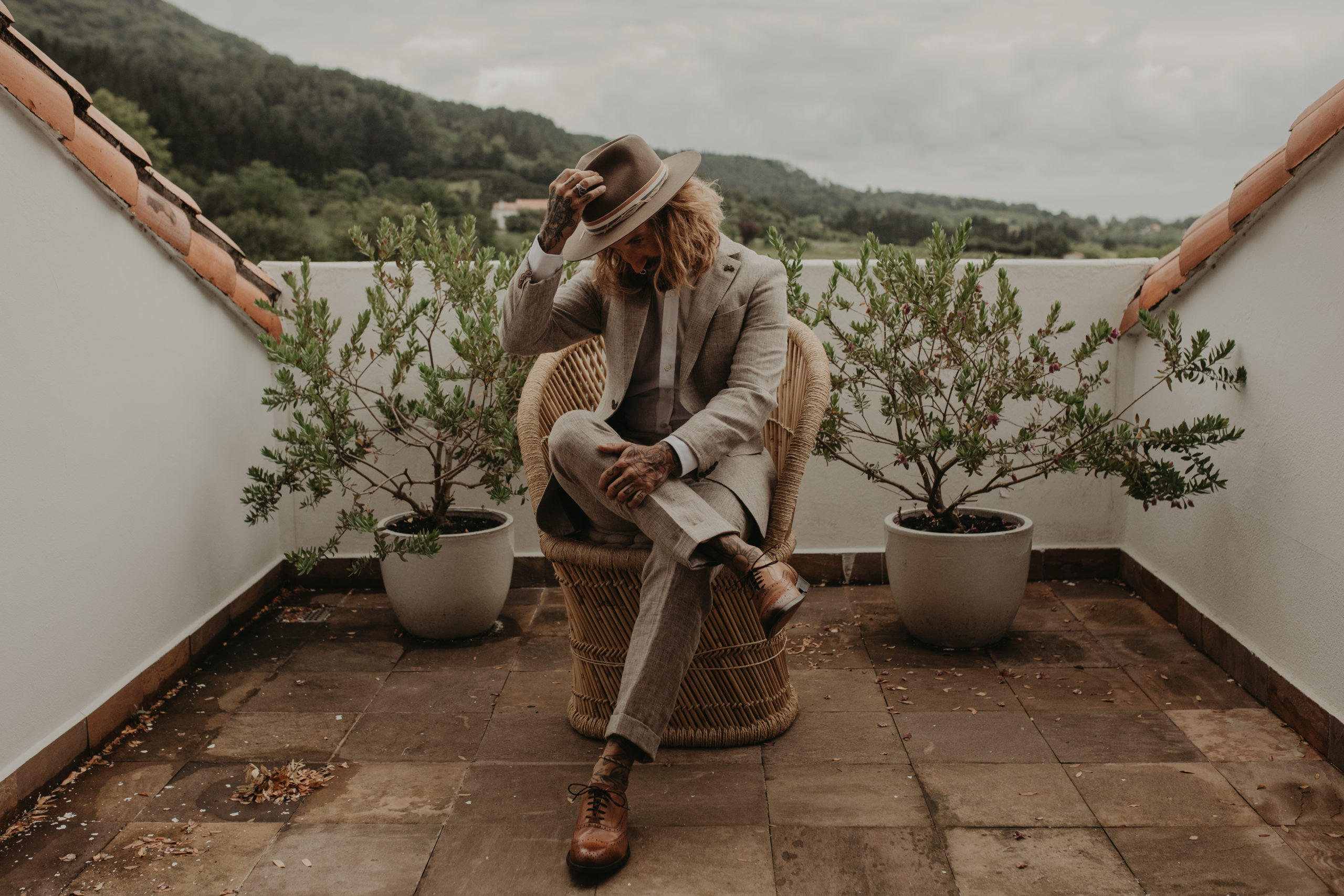 Novio posando con su traje y sombrero el día de su boda