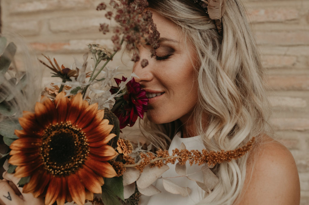 Novia oliendo su ramo de flores nupcial