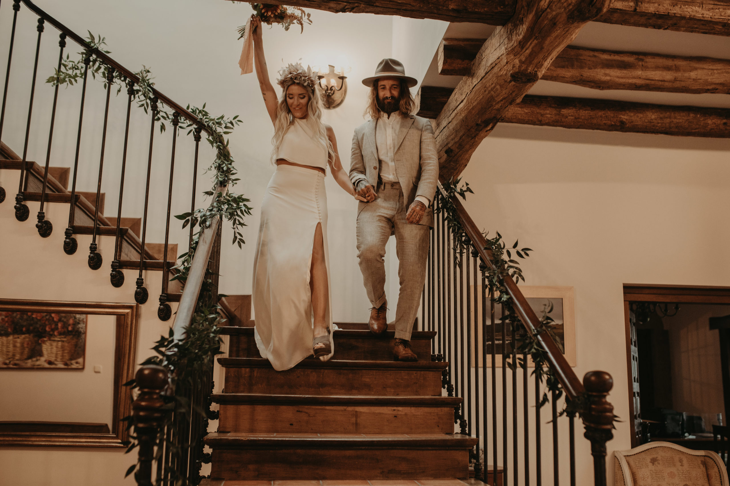 Pareja de novios bajando las escaleras a la ceremonia el día de su boda