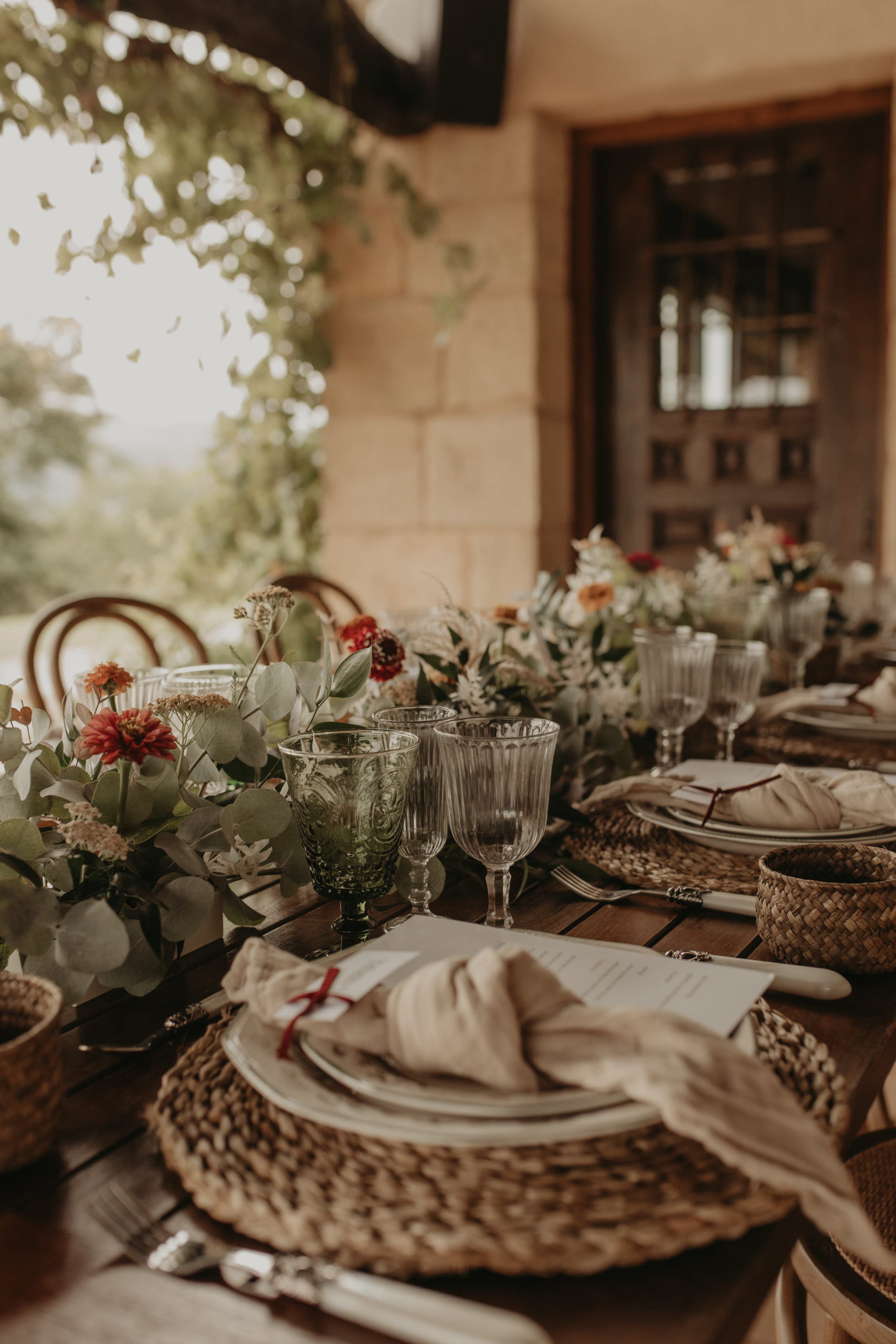 Bajoplatos, servilletas, copas, cubertería y decoración floral especial para un banquete nupcial
