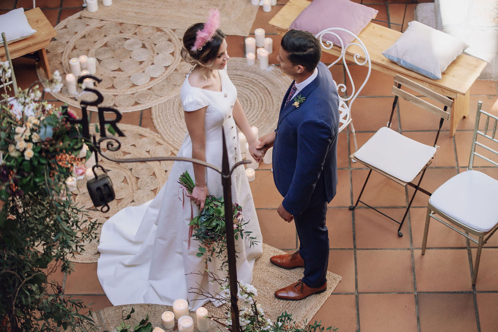 Posado de novios en una ceremonia romántica con diferentes sillas y alfombras de yute