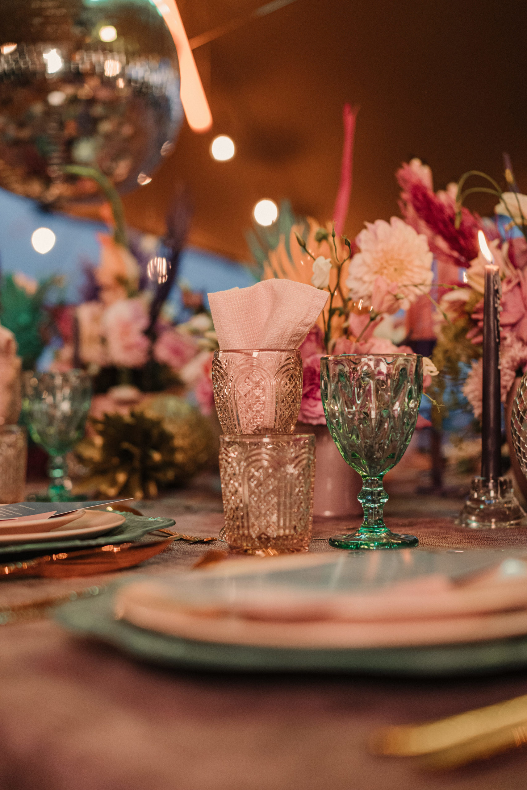 Copa turquesa y conjunto de vaso y copa rosa sobre la mesa