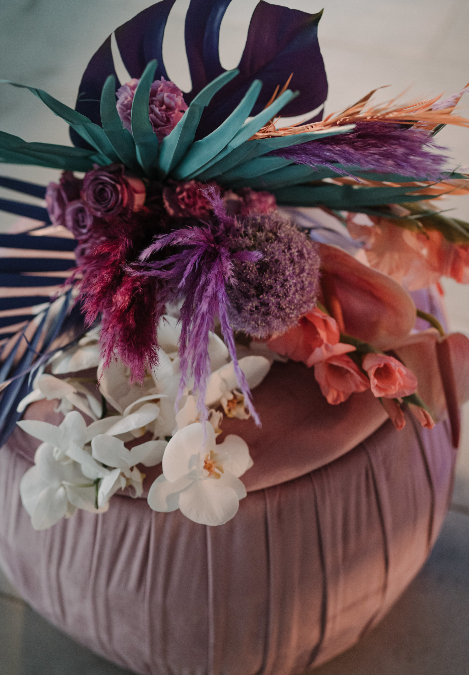 Ramo de novias colorido sobre un puff de terciopelo rosa