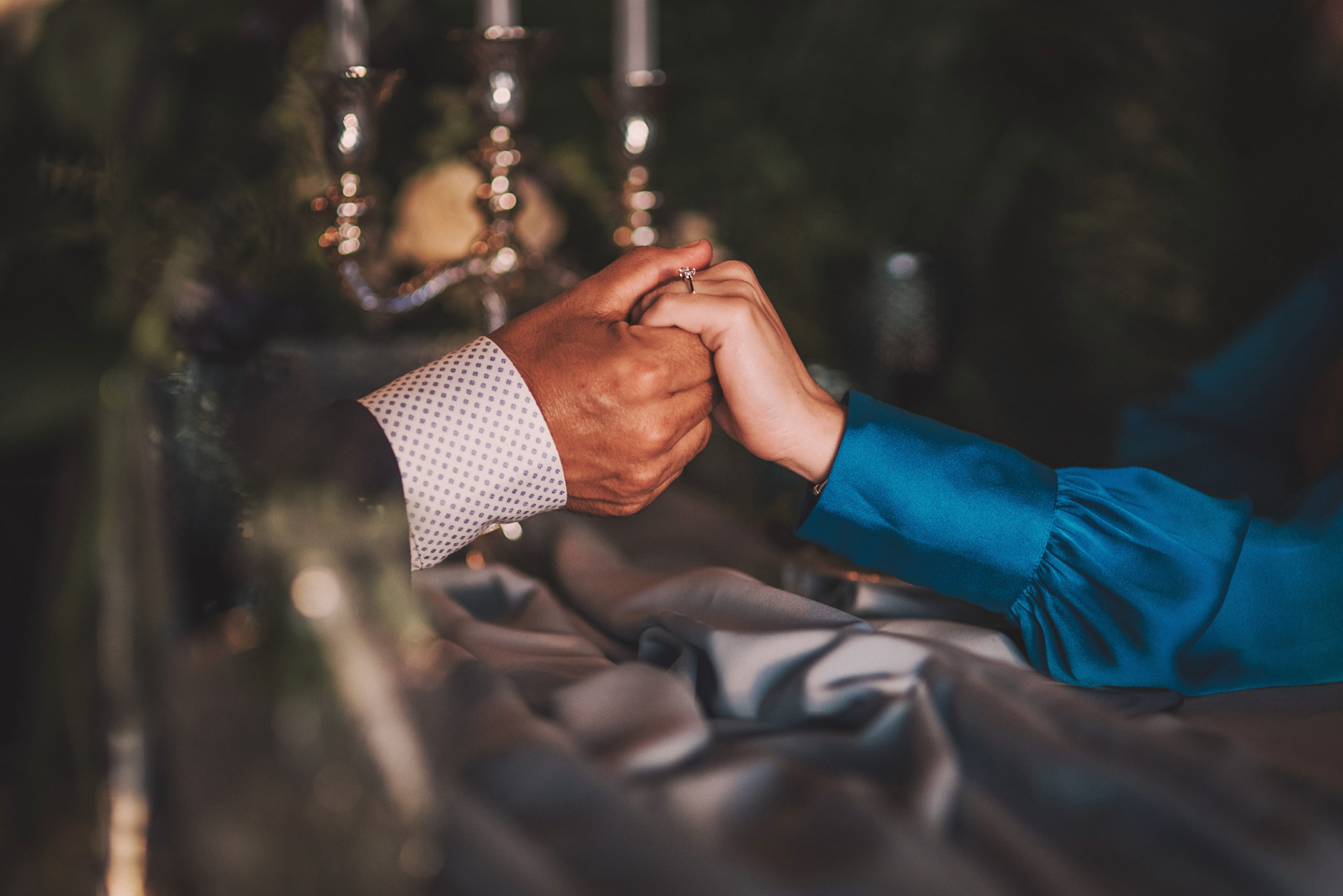 Manos de los novios en la mesa de banquete íntimo