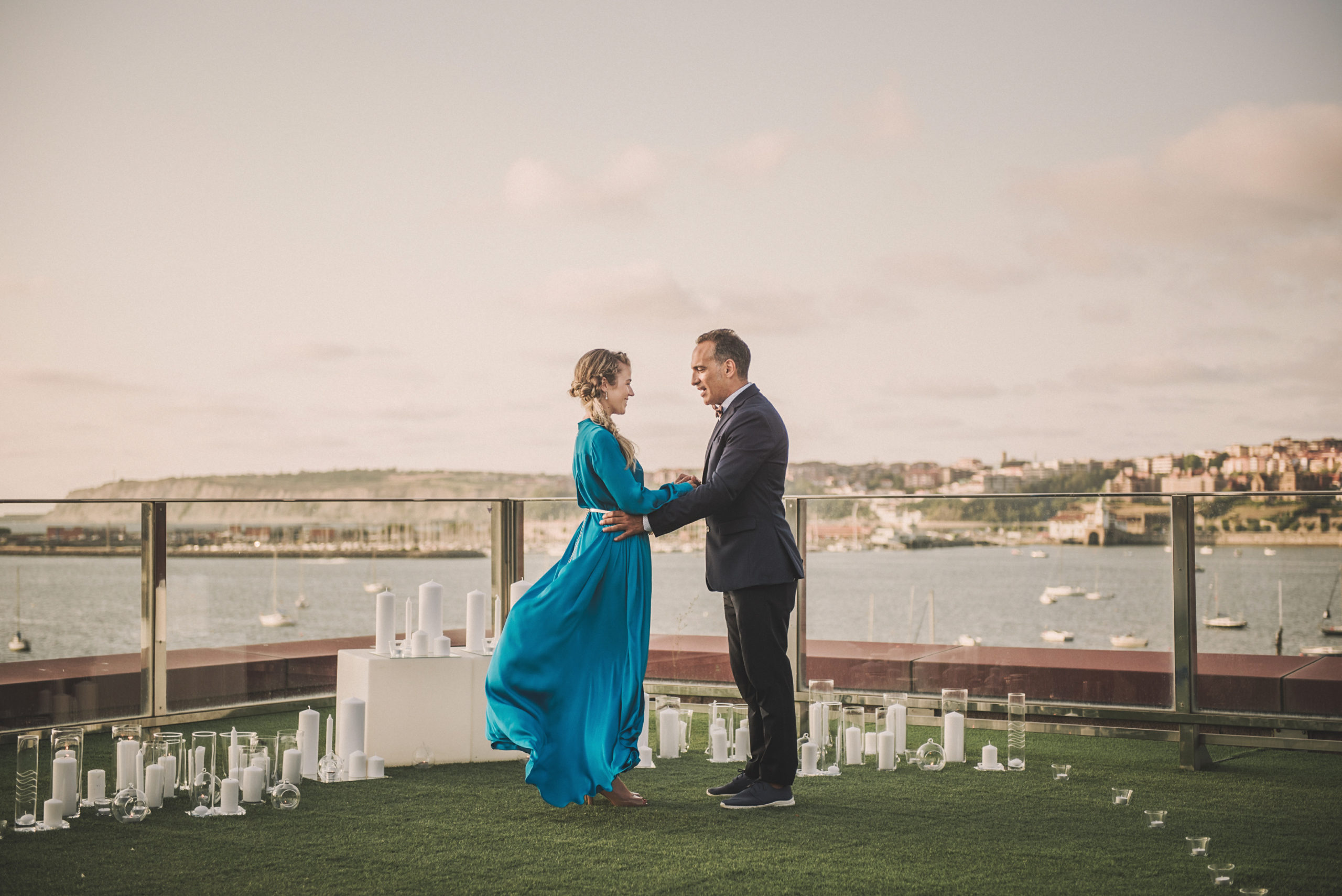 Momento pedida de mano novia vestida de azul y novio con traje frente al mar