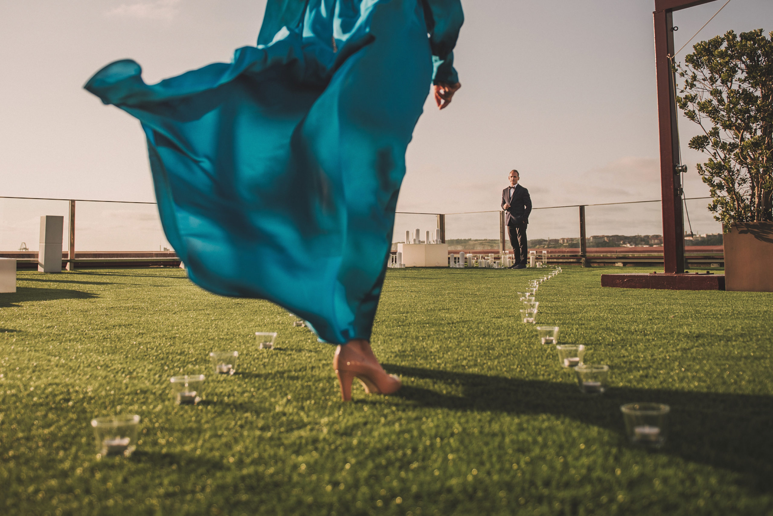 Vestido de novia azul pasando por pasillo de velas hasta llegar al novio