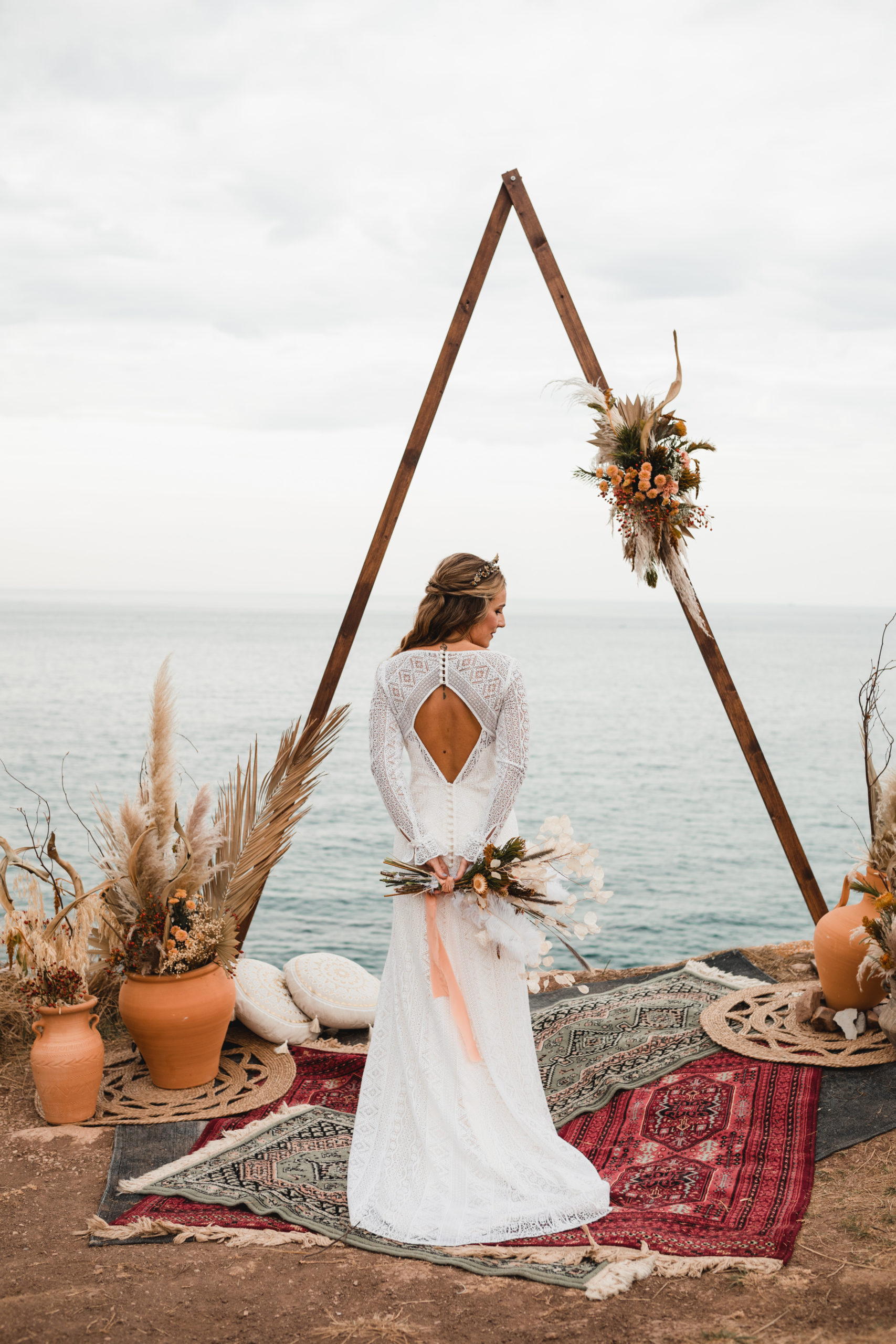 Posado de novia en la ceremonia nupcial con ramo de flores a la espalda