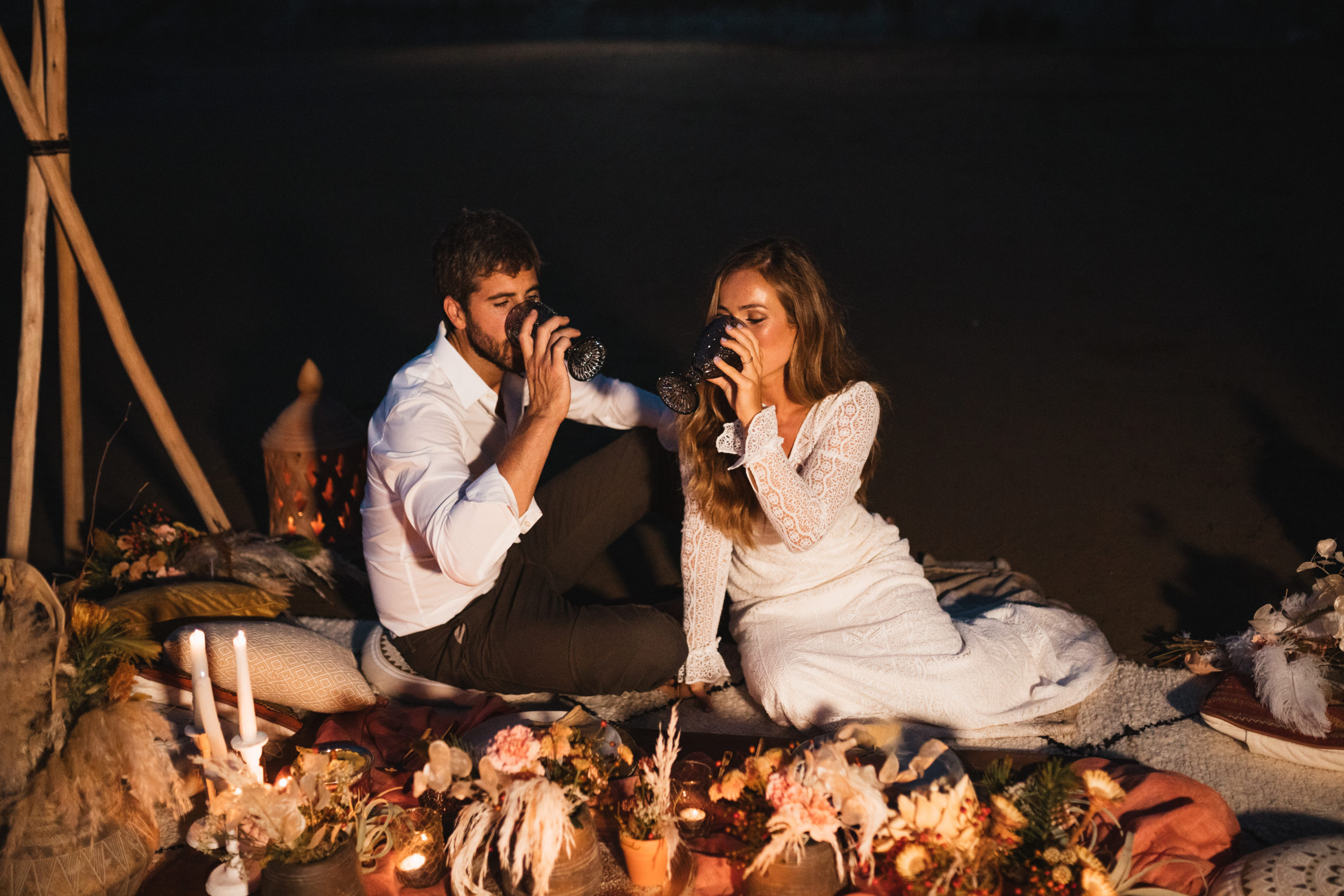 Novio y novia bebiendo de una copa, en una romántica cena íntima