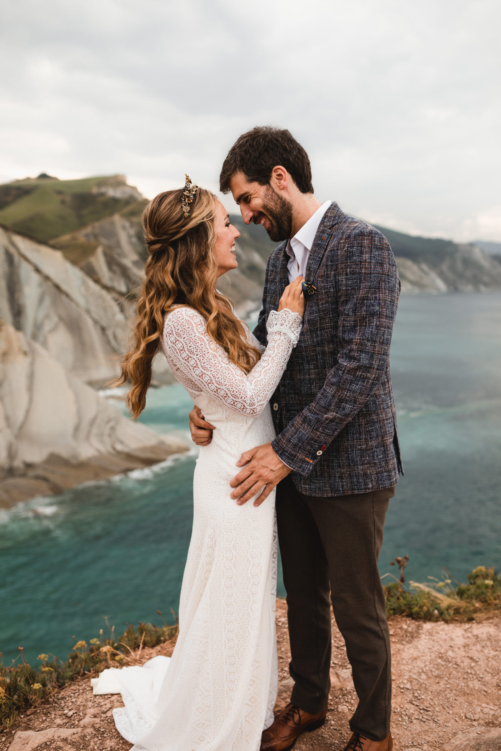 Mirada entre la novia y el novio con el mar y las montañas de fondo