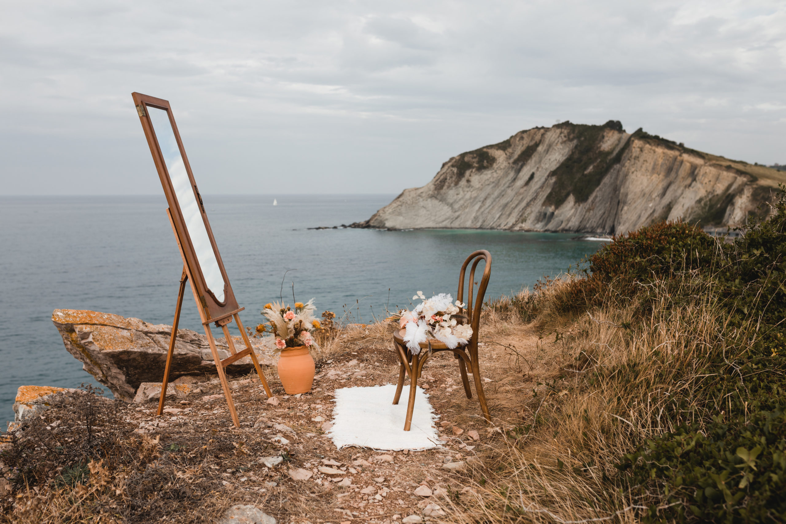 Espejo, silla, alfombra y decoración en el Flysch de Zumaia