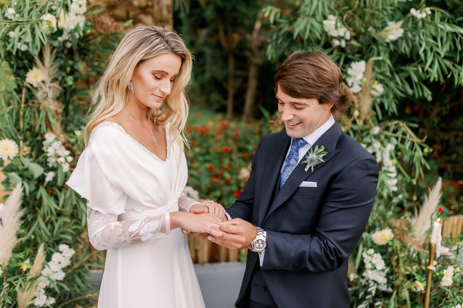 Novio pone a novia el anillo de compromiso el día de su boda