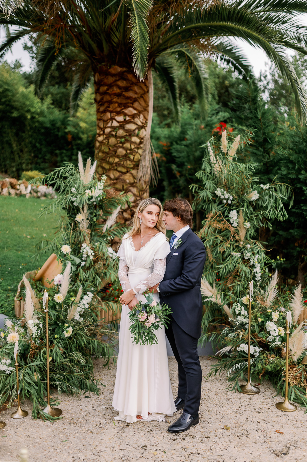 Novio con traje, novia con vestido y ramo de flores en el altar nupcial