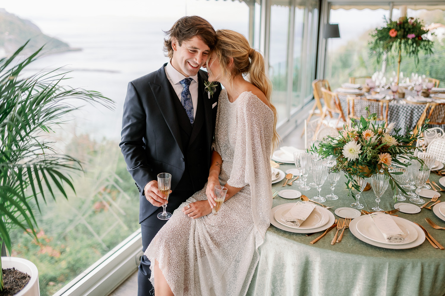 Novia y novio acurrucados sobre la mesa en el Mirador de Ulia, Donostia