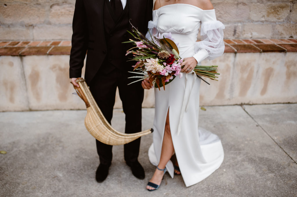 Novio cesta punta y novia con ramo de flores nupcial