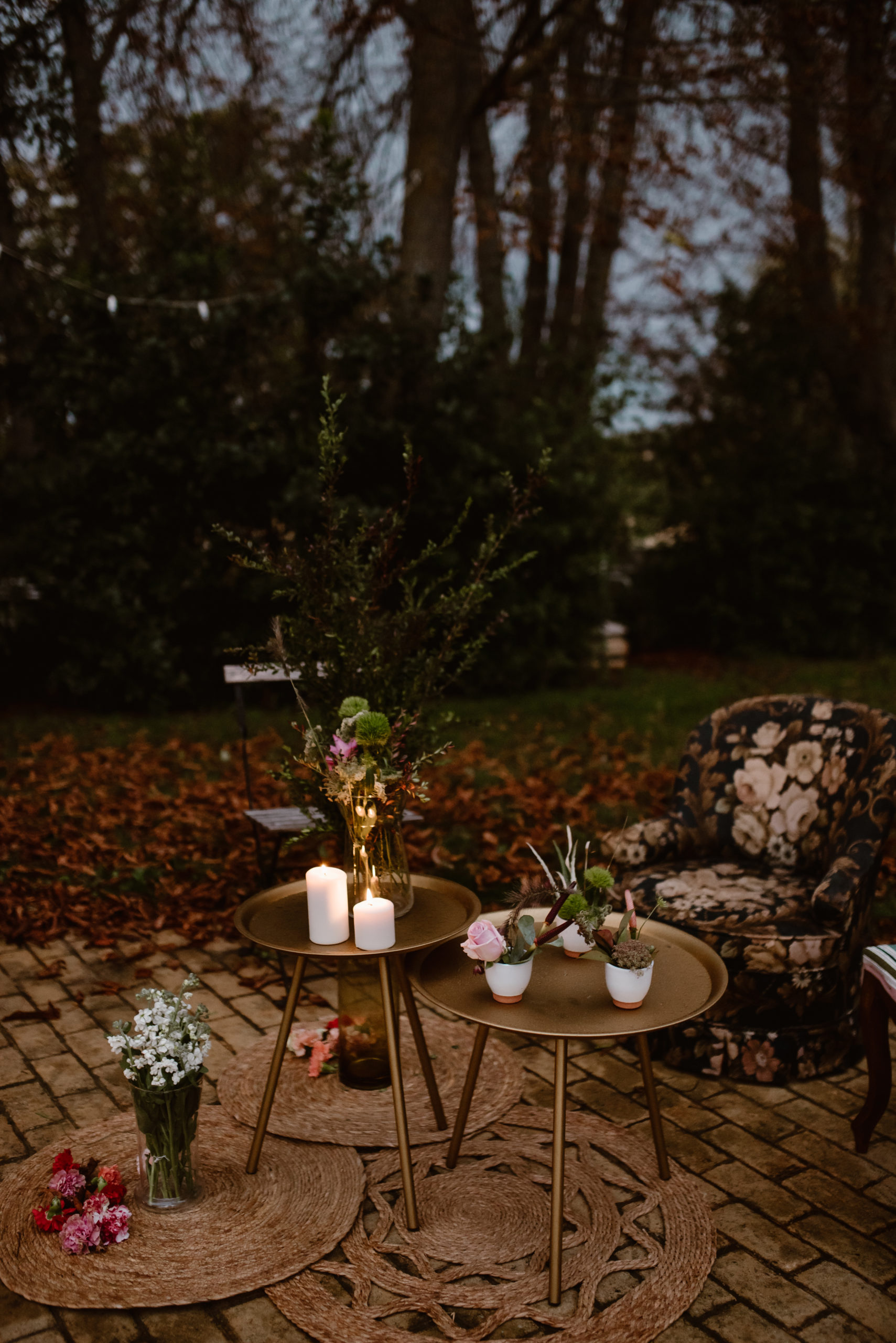 Mesa auxiliar dorada con alfombras redondas de yute y sillones de estampados florales en alquiler