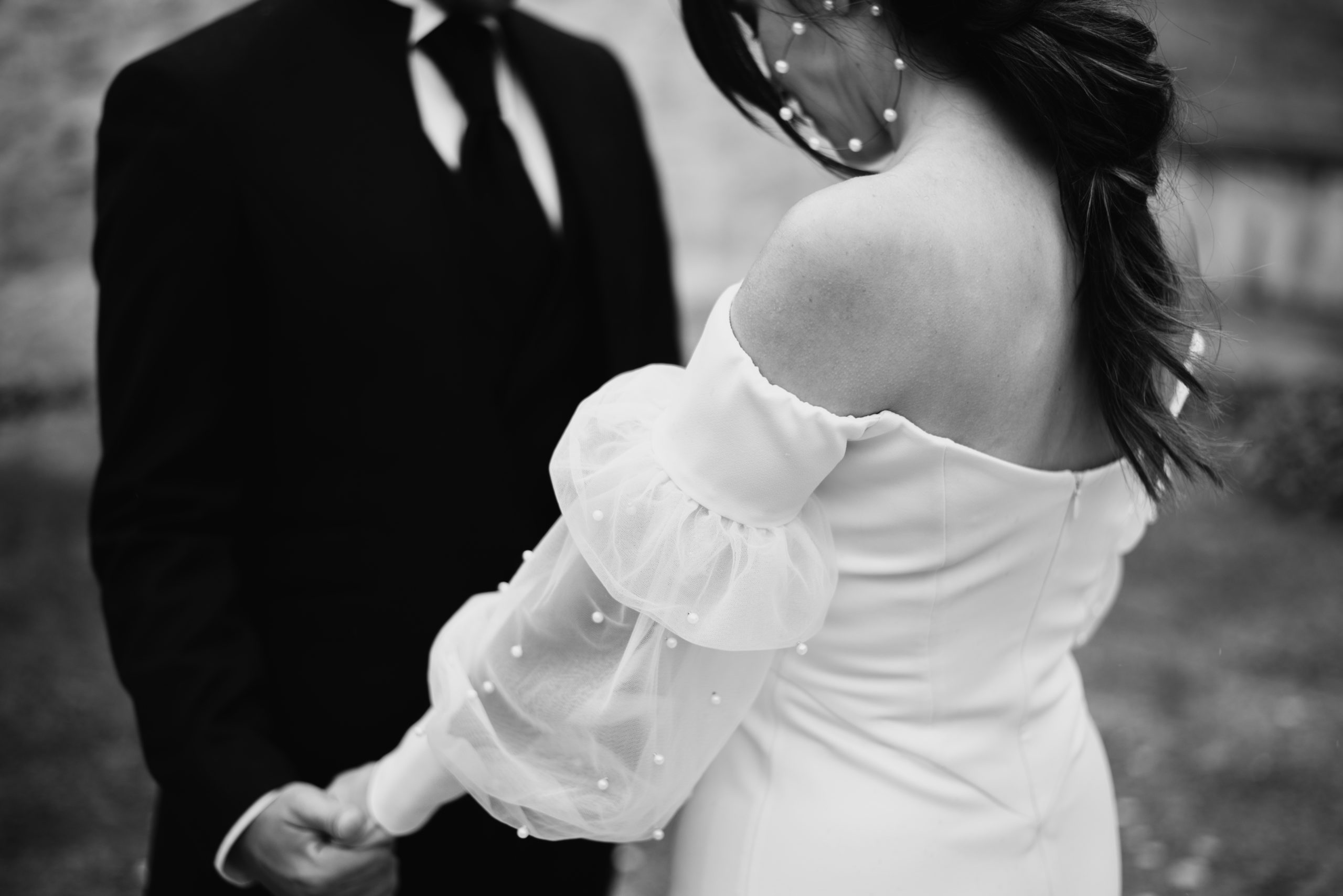 Novio con traje y novia con vestido agarrándose de la mano